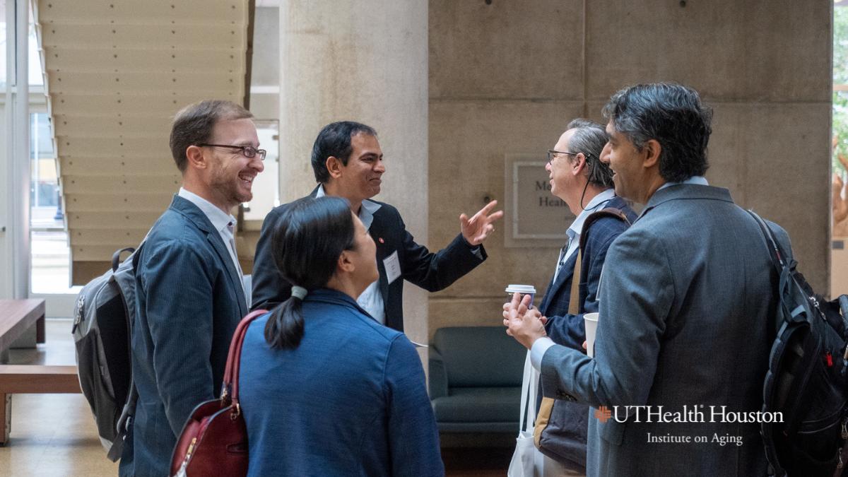 Naik, Samper, and Distinguished guests speaking at the Symposium on aging